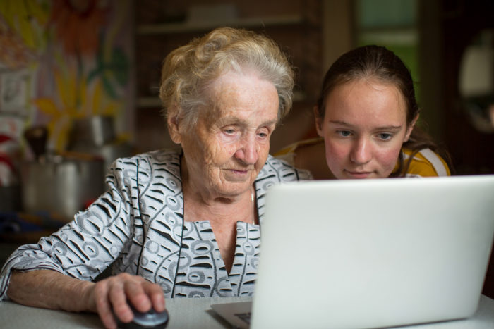 A young woman helps her grandma navigate the internet safely.